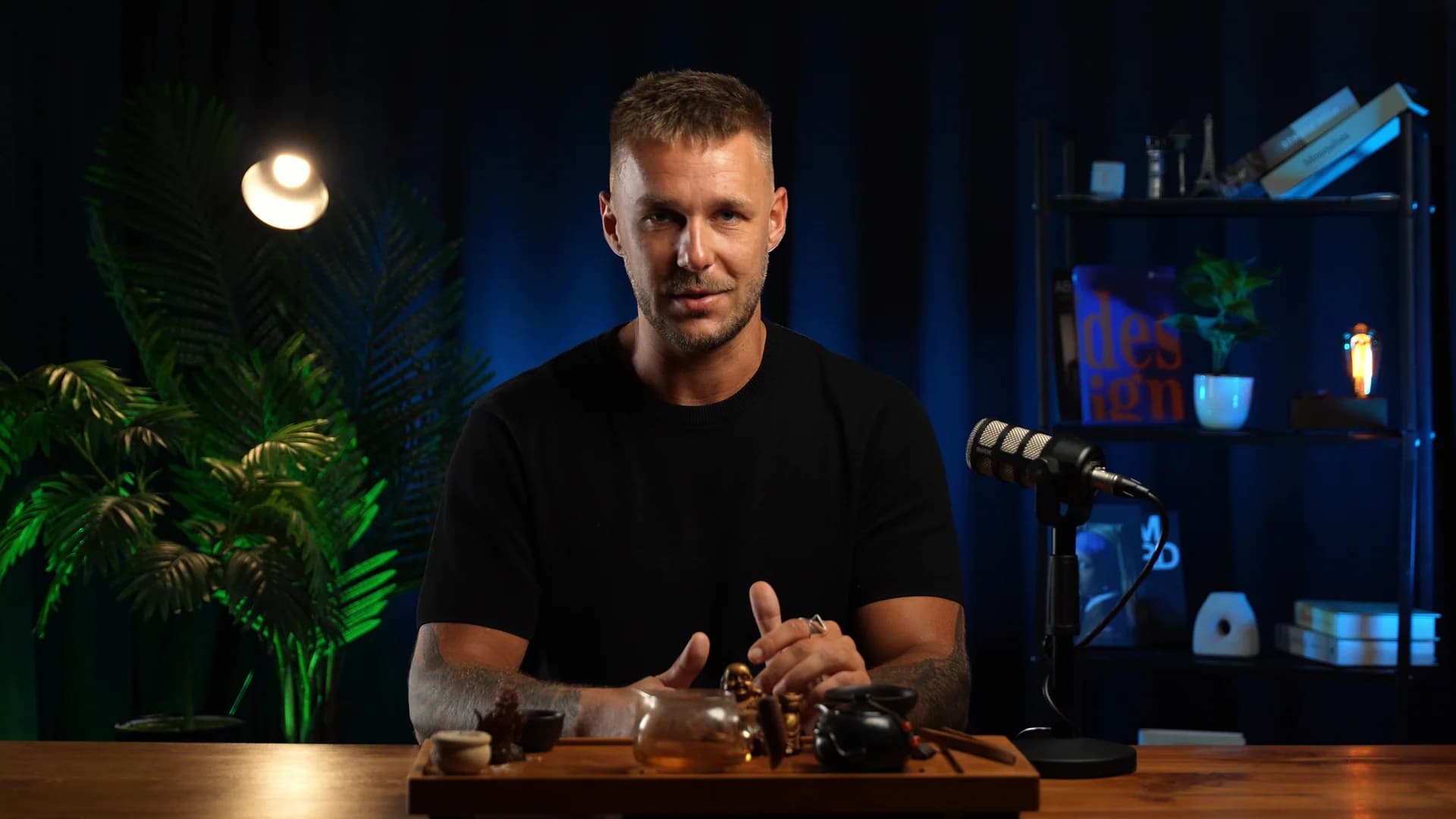 Presenter at a wooden table with blue studio lighting