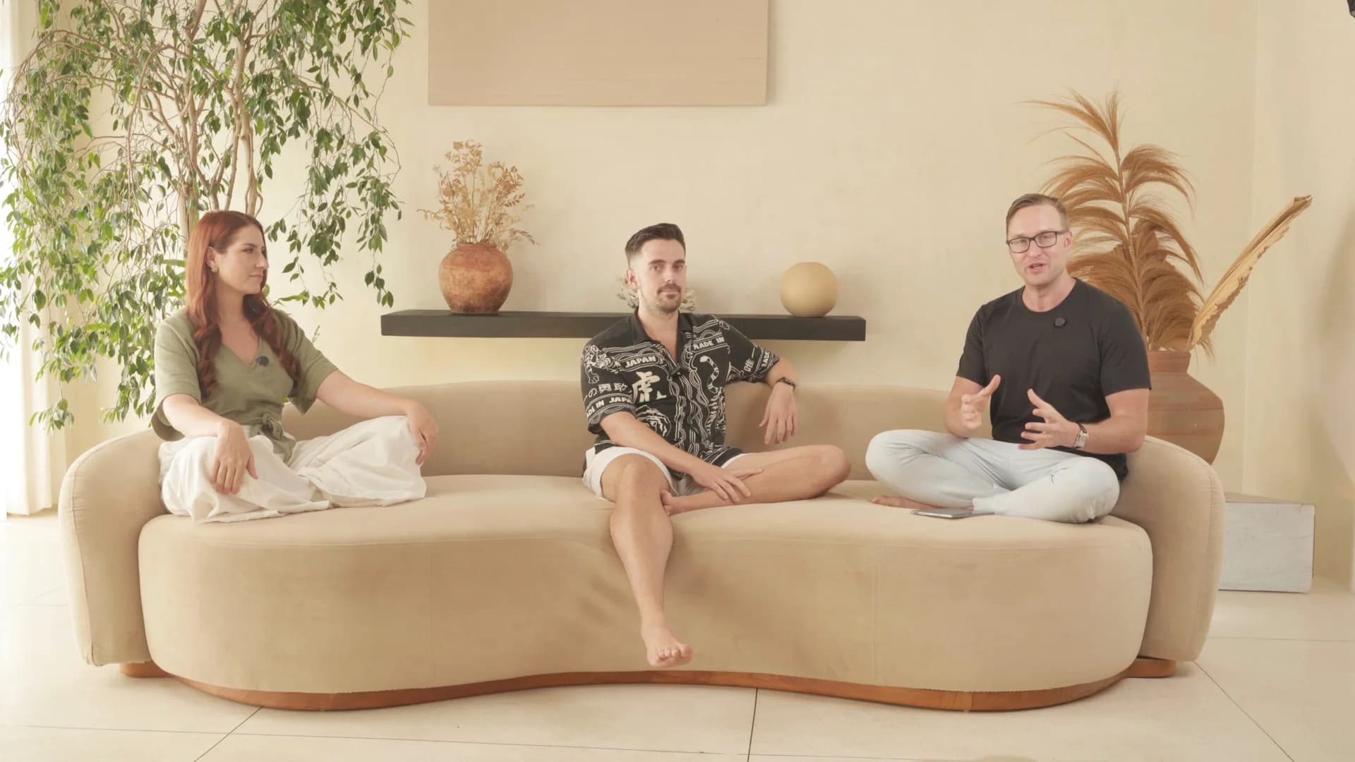 Three-person conversation on a sofa in a bright interior