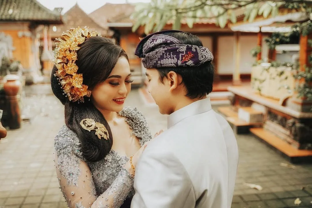 Bride and groom leaning close together in a courtyard