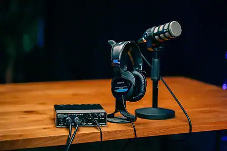 Microphone, headphones and audio interface on a recording desk