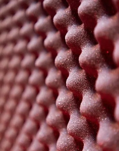 Close-up of red, textured acoustic wall panels for soundproofing and interior decor in South Africa.