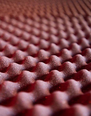Close-up of textured red foam mattress for comfortable sleep and relaxation.