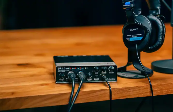 High-quality audio interface and headphones on Villo Studio desk for professional sound recording and production.