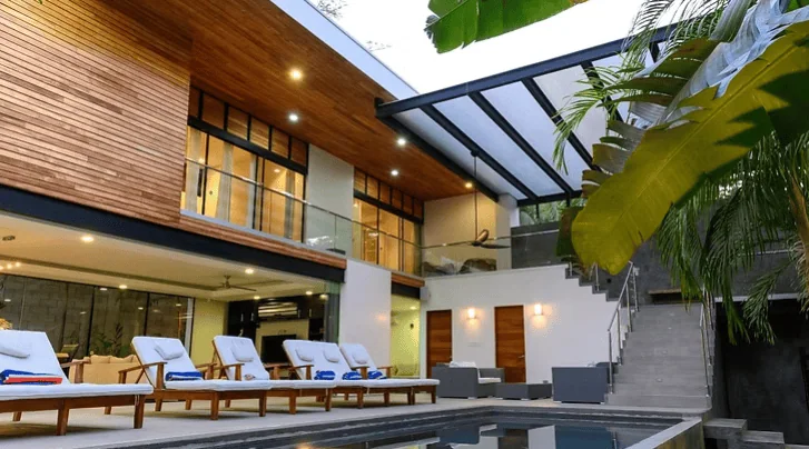 Luxurious modern villa with outdoor pool and stylish terraces in tropical setting.
