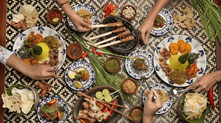 Vibrant African feast with traditional dishes on patterned tablecloth, showcasing cultural cuisine.