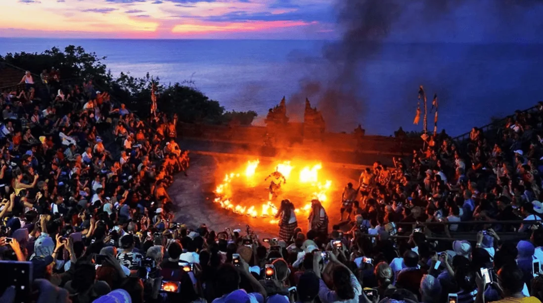 Colourful traditional Kecak dance performance at sunset on a cliff overlooking the Indian Ocean in Bali.