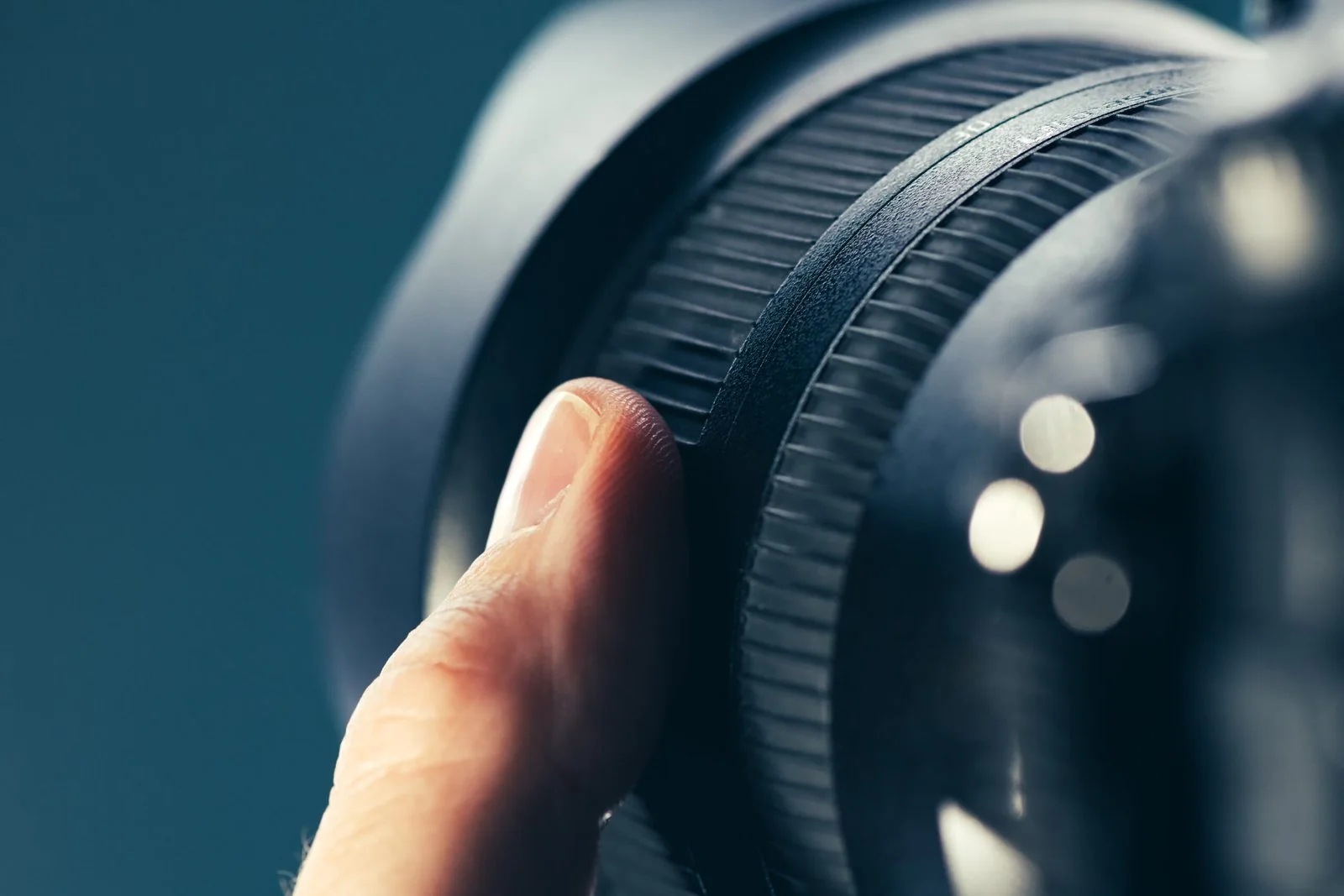 Photographer using zoom lens on DSLR camera, close up of finger rotating the ring on photographic equipment part